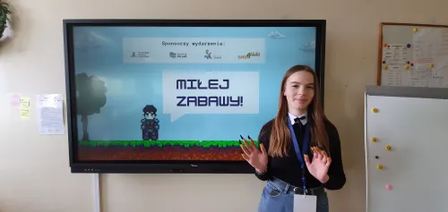 Powitanie uczestników na tle ekranu ze sponsorami