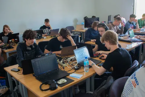 Drużyna przy laptopach rozwiązuje zadania